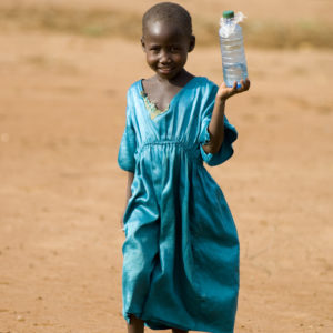 young child transporting an old plastic bottle full of water.